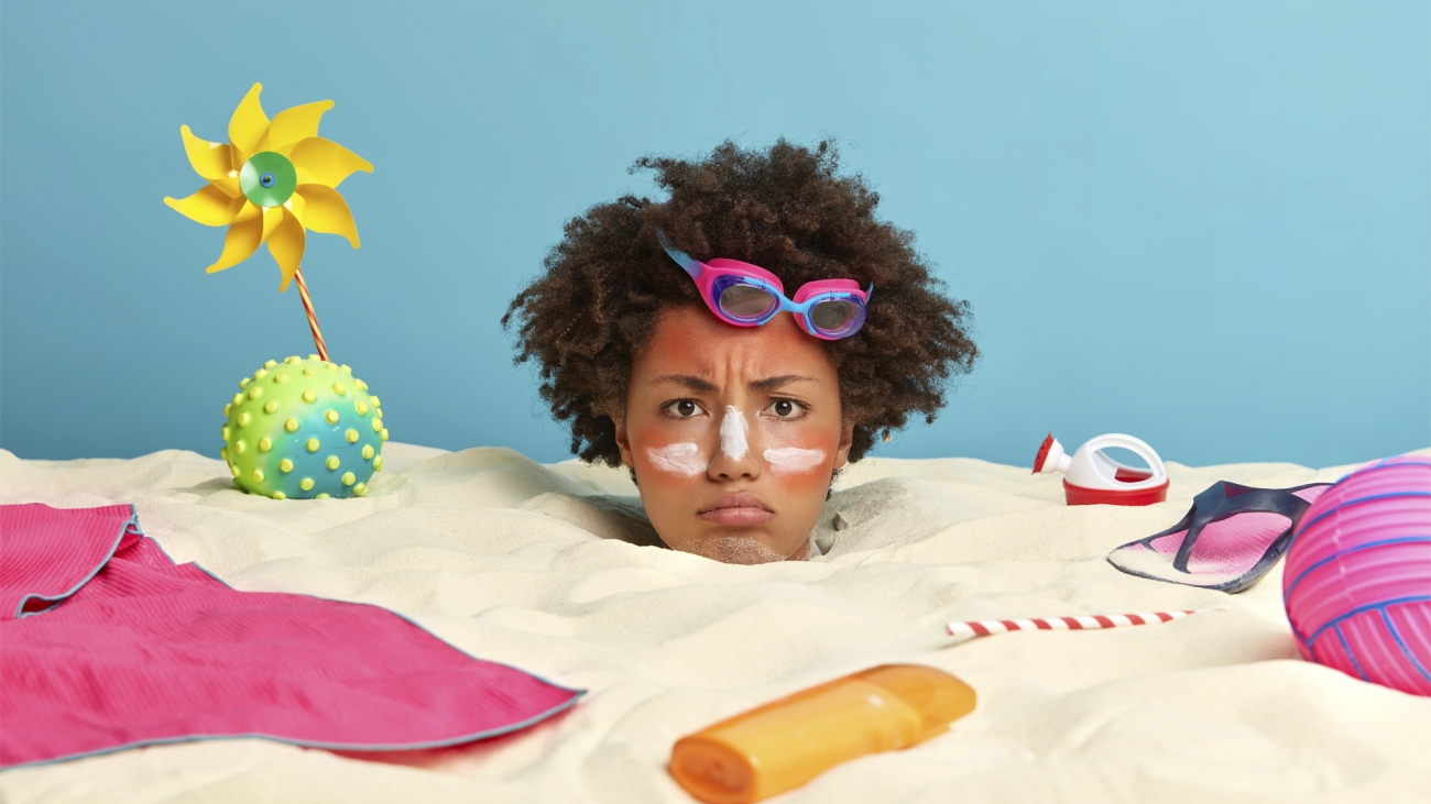 young-woman-head-with-sunscreen-cream-on-face-surrounded-by--accessories